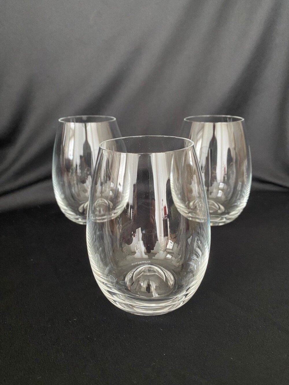 Set of three (3) Dartington crystal stemless wine glasses.